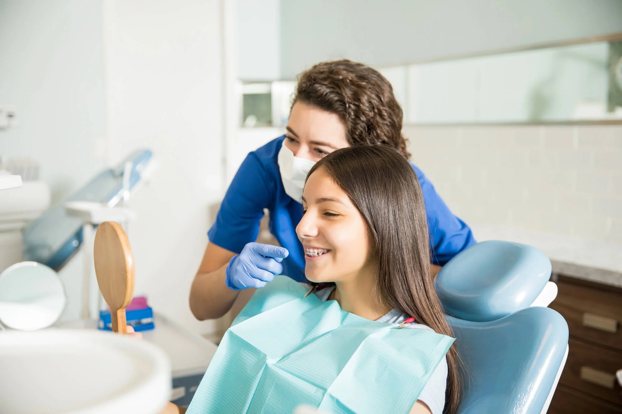 Dentist showing braces to smiling teen dentist in Edison NJ